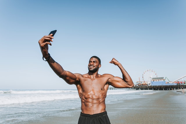 svalnatý muž robí selfie, pláž.jpg