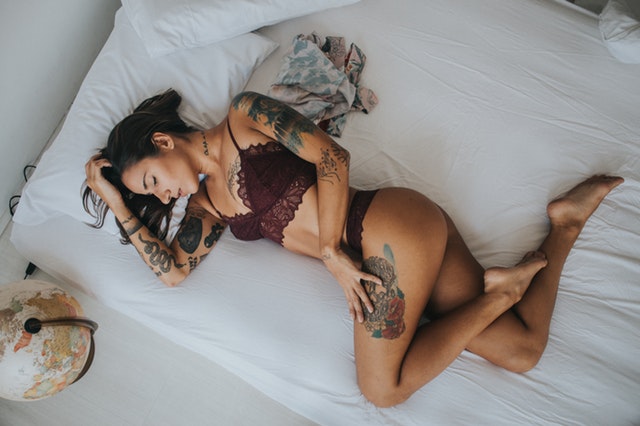 Žena v spodnej bielizni ležiaca v posteli