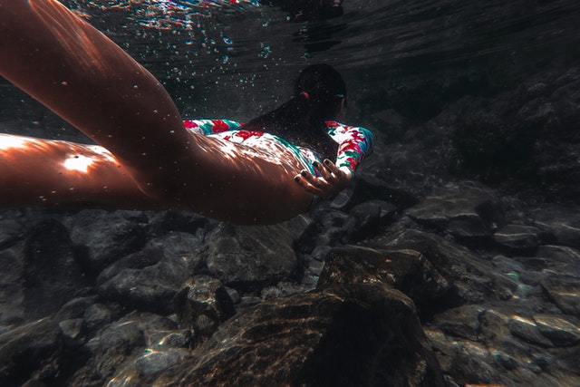 Žena vo farebných plavkách pláva vo vode.jpg